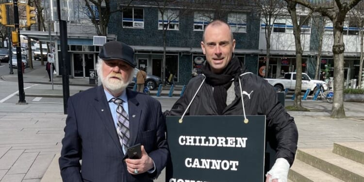 Canadian educator Barry Neufeld of Chilliwack, British Columbia, who faces a $750,000 fine for disagreeing with gender ideology, stands next to activist Billboard Chris.