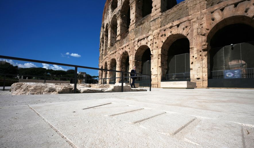 People walk in the new outdoor space created with travertine marble around the Colosseum during it's inauguration in Rome, Tuesday, March 17, 2026. (AP Photo/Andrew Medichini)