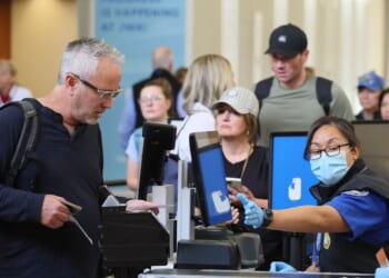 A traveler that does not have a Real ID is given a card stating he is not compliant at John Wayne Airport in Santa Ana, California, on May 7, 2025.