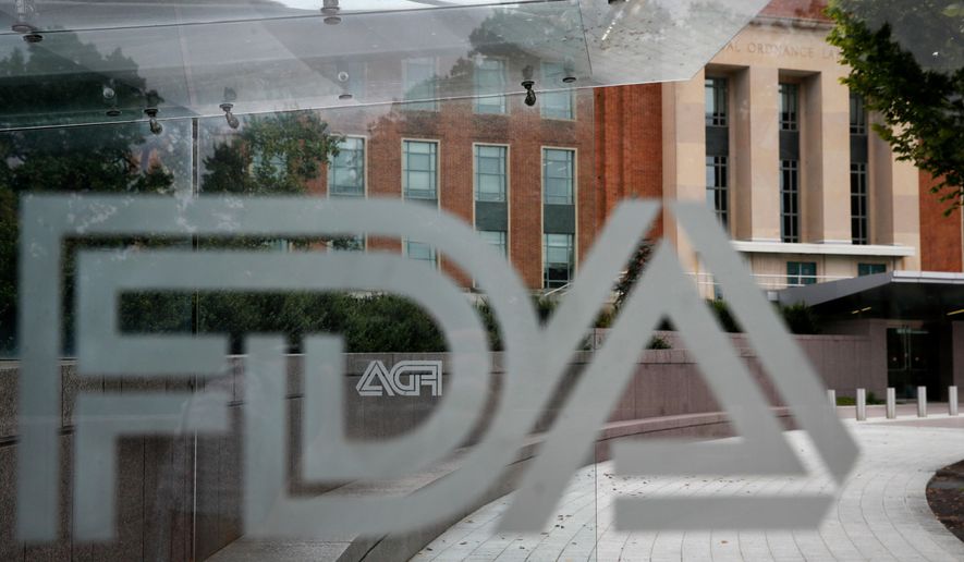 The U.S. Food and Drug Administration building is seen behind FDA logos at a bus stop on the agency's campus in Silver Spring, Md., Aug. 2, 2018. (AP Photo/Jacquelyn Martin, File)
