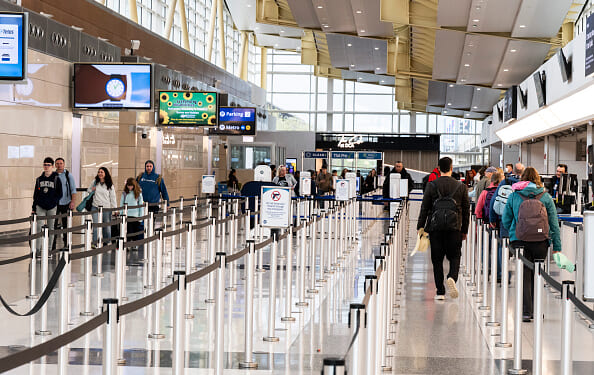 Travelers walk in the lines of Ronald Reagan International Airport on March 30, 2026.