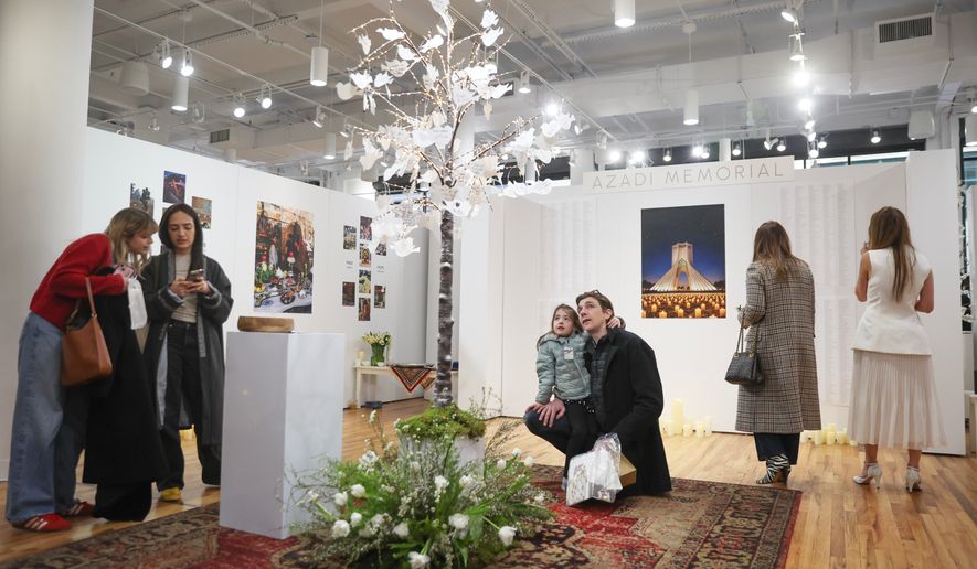 People interact with a dedicated memorial space to Iranian lives that were lost during a gathering in New York, on Saturday, March 14, 2026, for the upcoming Nowruz, Iranian/Persian New Year's day. (AP Photo/Heather Khalifa)