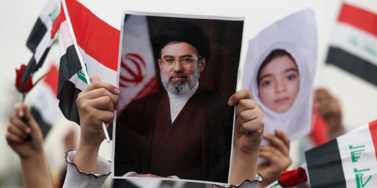 A schoolgirl holds up a poster of Iran's new supreme leader Mojtaba Khamenei during an anti-U.S. and Israel demonstration in Baghdad on March 12, 2026.