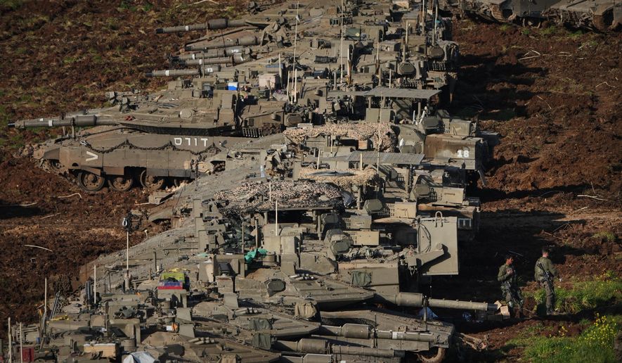 Israeli soldiers work on tanks at a staging area in northern Israel near the border with Lebanon, Friday, March 6, 2026. (AP Photo/Ariel Schalit)