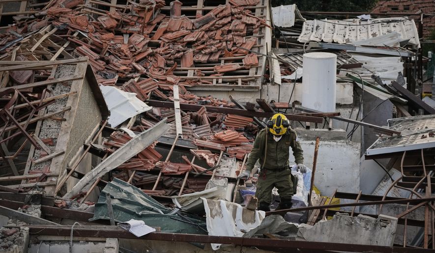 An officer from Israel's Home Front Command searches through the rubble of a destroyed house after it was struck by an Iranian missile in Beit Shemesh, Israel, Sunday, March 1, 2026. (AP Photo/Leo Correa)