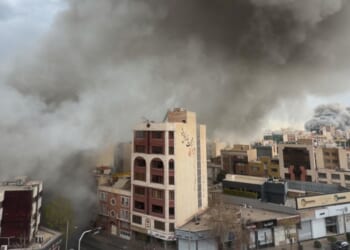 Plumes of smoke from two simultaneous strikes rise over Tehran, Iran, Monday. The attacks continued Tuesday with a reported strike on the city's airport.