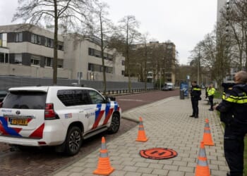 Police officers stand outside a Jewish school where an explosion was reported overnight in Amsterdam on March 14, 2026.