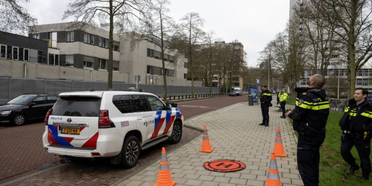 Police officers stand outside a Jewish school where an explosion was reported overnight in Amsterdam on March 14, 2026.