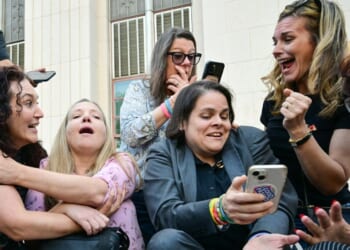 Laura Marquez-Garrett, center, in gray blazer, plaintiffs' attorney for the Social Media Victims Law Center, celebrates with family members of victims outside the Los Angeles Superior Court Wednesday as they react to news that a jury has found Meta and YouTube liable in a social media addiction trial. The jury found Meta and YouTube liable for harming a young woman through the addictive design of their social media platforms and ordered the companies to pay $3 million in damages.