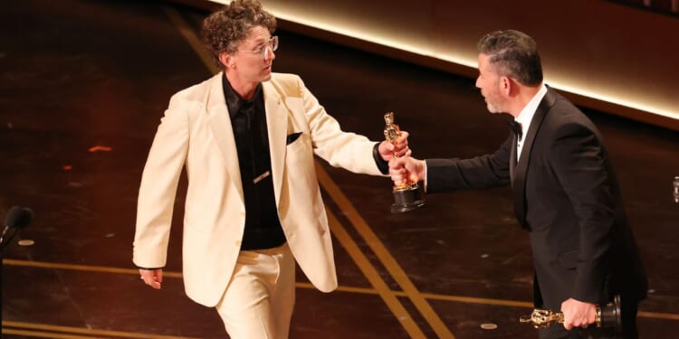 David Borenstein, left, accepts the Documentary Feature award from Jimmy Kimmel Sunday for "Mr. Nobody Against Putin" during the 98th Oscars in Hollywood, California. Ratings for the show dropped to the lowest the Oscars have seen in four years.