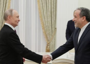 In this pool photograph distributed by the Russian state agency Sputnik, Russian President Vladimir Putin shakes hands with Iranian Foreign Minister Abbas Araghchi during a meeting at the Kremlin in Moscow on April 17, 2025.