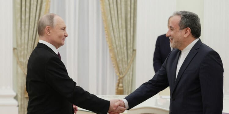 In this pool photograph distributed by the Russian state agency Sputnik, Russian President Vladimir Putin shakes hands with Iranian Foreign Minister Abbas Araghchi during a meeting at the Kremlin in Moscow on April 17, 2025.