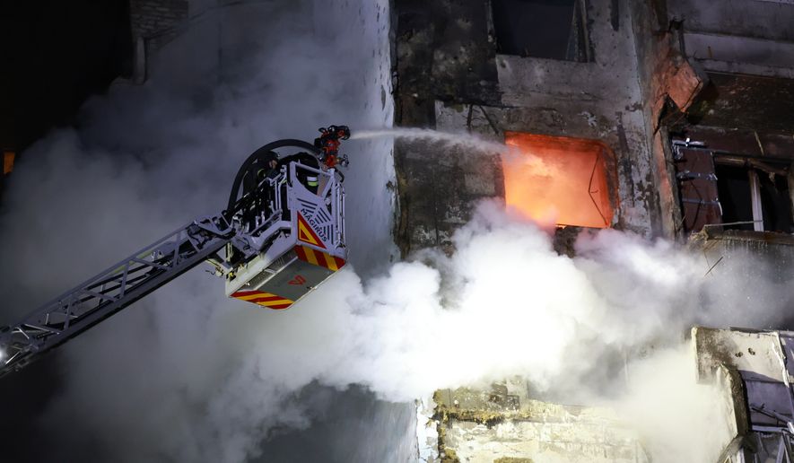 Rescue workers try to put out a fire of a residential building burning after a Russian drone attack on Zaporizhzhia, Ukraine, Tuesday, March 24, 2026. (AP Photo/Kateryna Klochko)