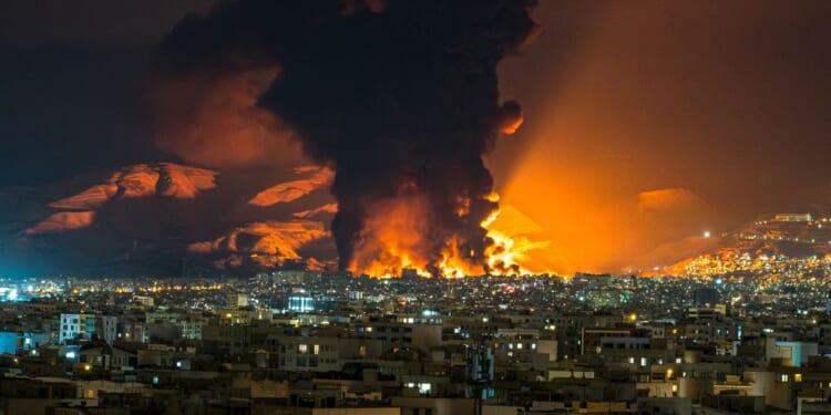 Smoke and flames rise at the site of airstrikes Saturday on an oil depot in Tehran, Iran.