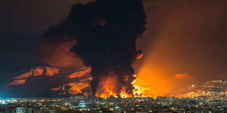 A large plume of smoke rises at the site of multiple airstrikes on an oil depot in Tehran on March 7, 2026.