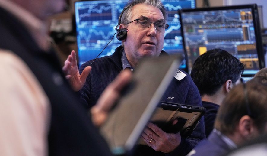 Trader John Bishop works on the floor of the New York Stock Exchange, Friday, Feb. 20, 2026. (AP Photo/Richard Drew)
