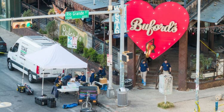 Members of the FBI conduct an investigation near Buford's bar Sunday in Austin, Texas. Two victims were killed and 14 others hospitalized following a mass shooting early Sunday morning. The gunman was also killed.