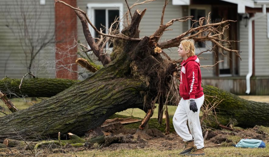 A volunteer works to clear debris a day after a storm whipped up a tornado through the area, in Union City Mich., Saturday, March 7, 2026. (AP Photo/Nam Y. Huh)