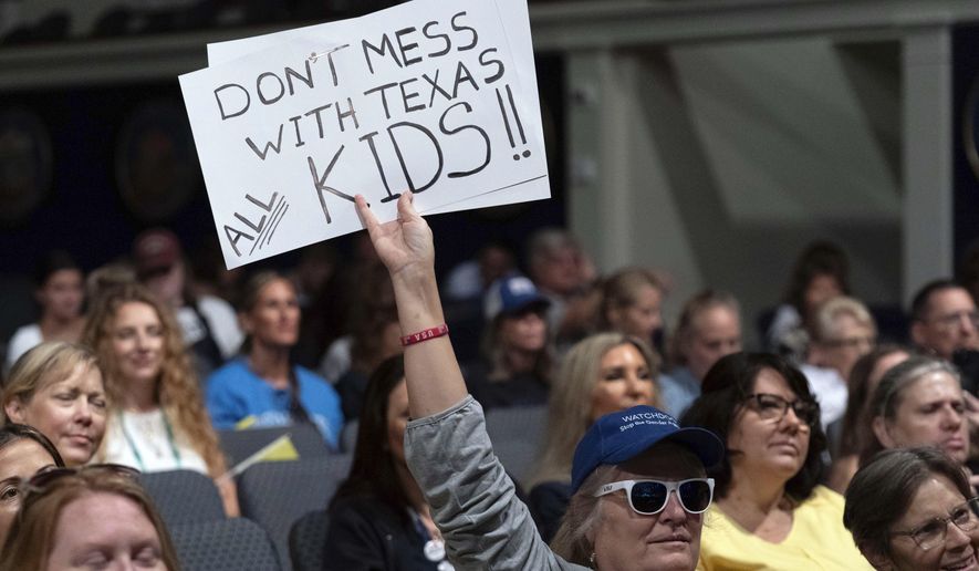 An attendee holds up a sign at the Moms for Liberty National Summit in Washington, Saturday, Aug. 31, 2024. (AP Photo/Jose Luis Magana)