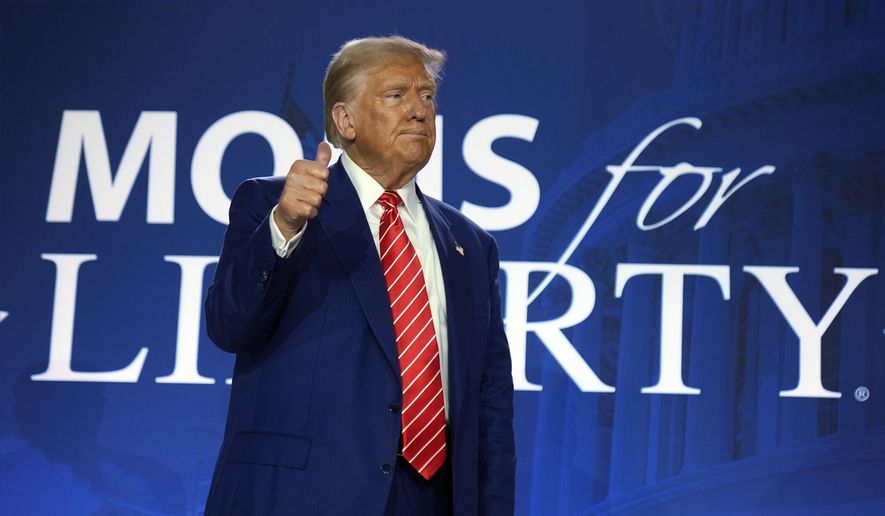 Republican presidential nominee former President Donald Trump gestures after speaking with Moms for Liberty co-founder Tiffany Justice during an event at the group's annual convention in Washington, Friday, Aug. 30, 2024. (AP Photo/Mark Schiefelbein)
