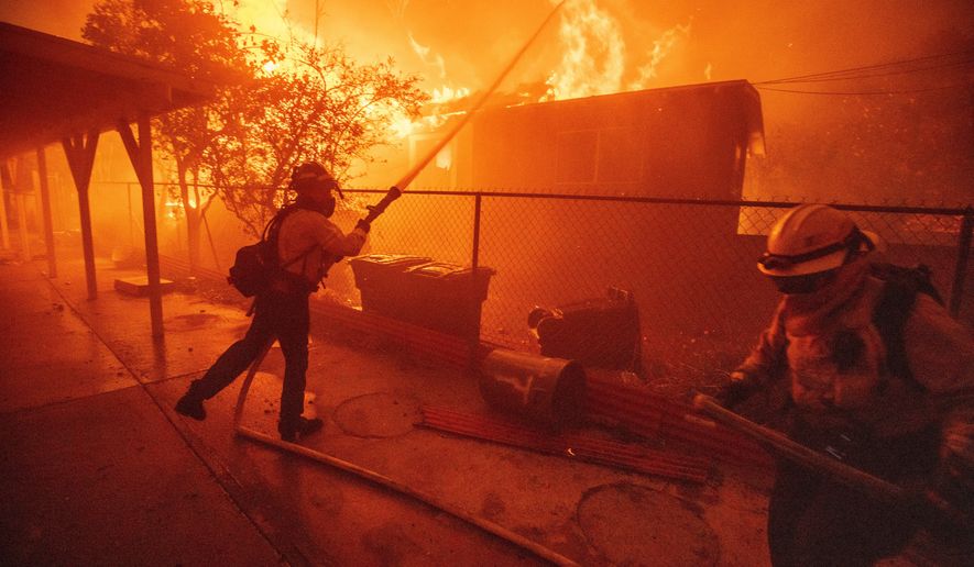 Firefighters try to protect a structure as the Eaton Fire advances, Jan. 8, 2025 in Altadena, Calif. (AP Photo/Ethan Swope, File)