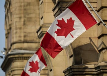 Canadian flags wave at the Capitol Building in Ontario, Canada.