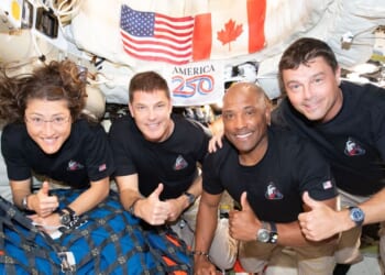 The Artemis II crew pose for. a photograph inside the Orion spacecraft on their way home from the far side of the Moon on April 6, 2026.