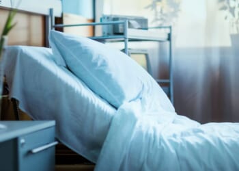 A side view of an empty hospital bed in a clinic.