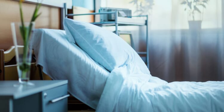 A side view of an empty hospital bed in a clinic.