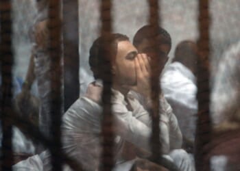 Egyptian defendants await their trial behind the bars of a jail in Cairo on May 30, 2015.