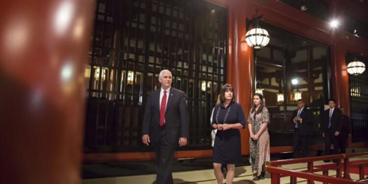 Mike Pence walks in Japan flanked by team members on April 18, 2017.