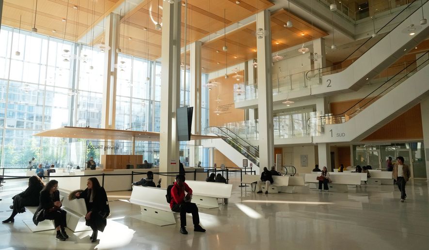 People wait inside the Paris courthouse, in Paris, France, Monday, April 20, 2026. (AP Photo/Michel Euler)