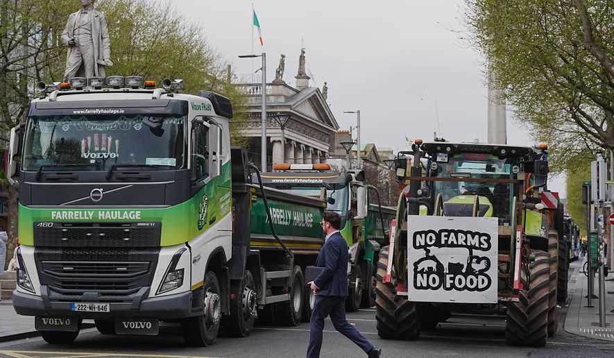 A man crosses a road where vehicles are parked on O'Connell Street, on the second day of a national fuel protest against rising fuel prices, in Dublin, Ireland, Wednesday April 8, 2026. (Brian Lawless/PA via AP)