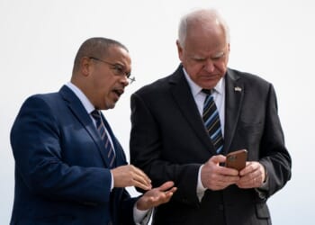 Minnesota Governor Tim Walz and Minnesota Attorney General Keith Ellison await the arrival of then-U.S. Vice President Kamala Harris at the Minneapolis-St. Paul International Airport in Saint Paul, Minnesota, on March 14, 2024.