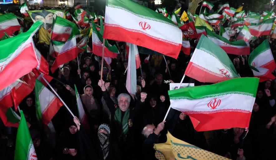 Pro-government demonstrators wave Iranian flags during a gathering in Tehran, Iran, Saturday, April 11, 2026. (AP Photo/Vahid Salemi)