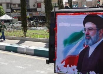 A woman walks past a banner depicting Iran's new supreme leader Ayatollah Mojtaba Khamenei on a street in Tehran in a photo taken April 5.
