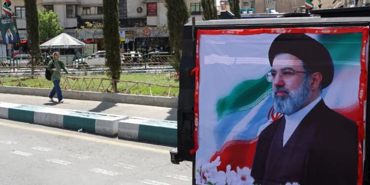 A woman walks past a banner depicting Iran's new supreme leader Ayatollah Mojtaba Khamenei on a street in Tehran in a photo taken April 5.