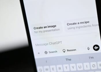 An illustration photograph taken on Feb. 20, 2025, shows the ChatGPT app and website are displayed on a phone and laptop screens, in a residential property in Guildford, south of London.