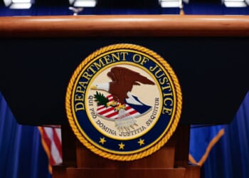 The seal of the Department of Justice sits on a podium in the Department of Justice headquarters in Washington, DC on April 7, 2026.