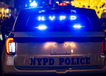 A New York City Police Department night patrol car stops in traffic.
