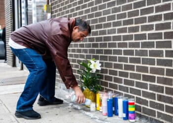 A man lights a candle at the corner where a 7-month-old baby was killed by a stray bullet while sitting in her stroller in Brooklyn Wednesday afternoon.