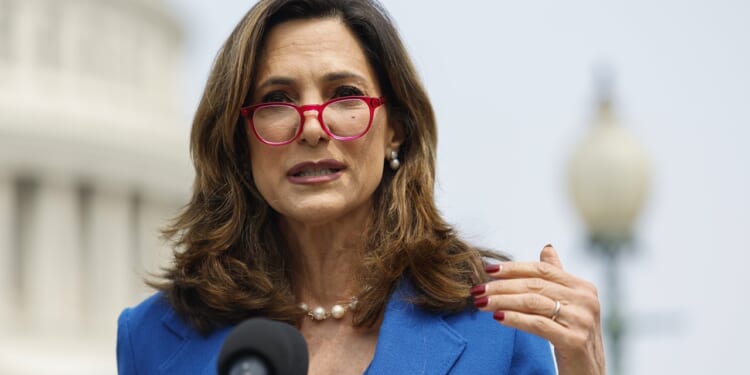 Maria Salazar speaking into microphones