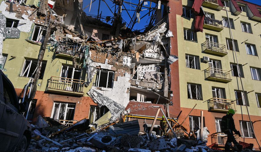 A rescue worker walks in front of residential building which was heavily damaged after a Russian strike in Odesa, Ukraine, Monday, April 6, 2026. (AP Photo/Michael Shtekel)