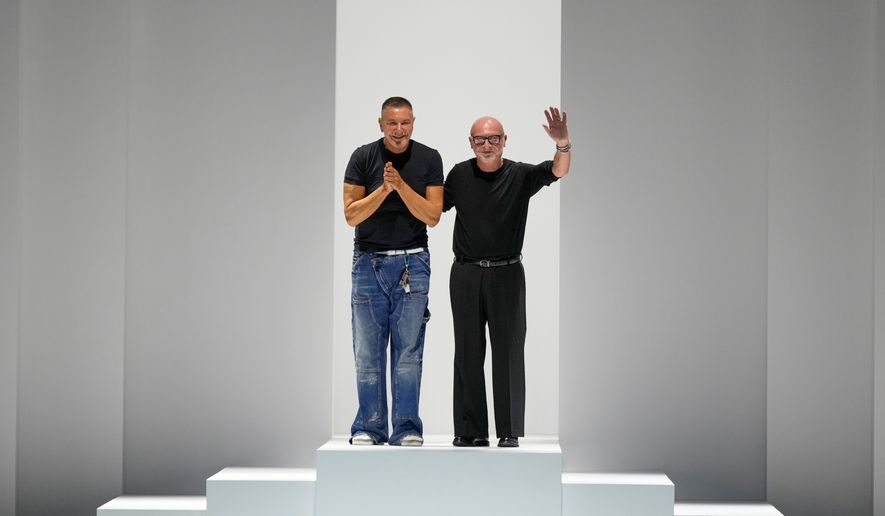 Designers Stefano Gabbana, left, Domenico Dolce accept applause after the Dolce & Gabbana Spring/Summer 2026 collection presented in Milan, Italy, Saturday, Sept. 27, 2025. (AP Photo/Luca Bruno, File)