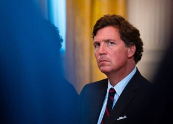 Former Fox News host Tucker Carlson looks on at a meeting with oil executives in the East Room of the White House on Jan. 8, 2026 in Washington, DC.
