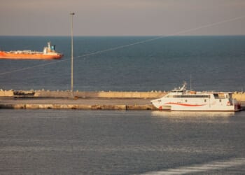 A police speed boat patrols the port as oil tankers and high speed crafts sit anchored at Muscat Anchorage near the Strait of Hormuz on March 30, 2026, in Muscat, Oman.