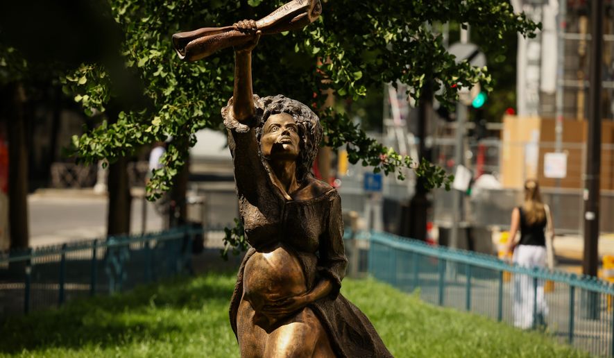 A statue is photographed by French artist Didier Audrat in Paris, Wednesday, May 27, 2026, honoring the memory of the abolition of slavery, depicting Solitude, the daughter of an African slave who was raped by a sailor aboard the ship transporting her to the Caribbean, holding the proclamation of Louis Delgres, an anti-slavery resistance leader calling for resistance and struggle. (AP Photo/Thomas Padilla)