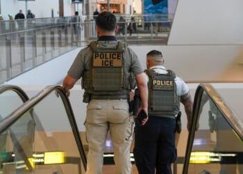 Two ICE agents ride down an escalator at LaGuardia Airport in New York on March 28, 2026.