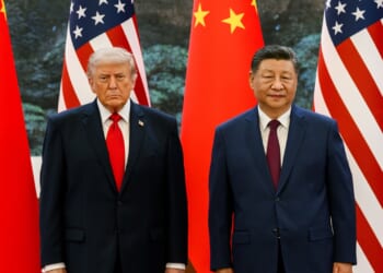 Donald Trump and Xi Jinping standing in front of flags