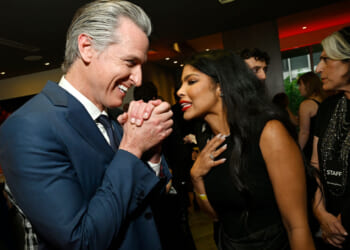 Gavin Newsom clasps his hands with glee while talking to Olivia Igbokewe Curry.